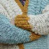 Detail pleteného svetru z vlny The Wave Wool v barvách Natural, Aquamarin a Mustard