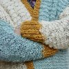 Detail pleteného svetru na 15mm jehlicích z vlny The Wave Wool v barvách Natural, Aquamarin a Mustard